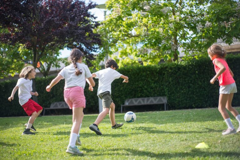 Kinder spielen Fussball auf dem Feld
